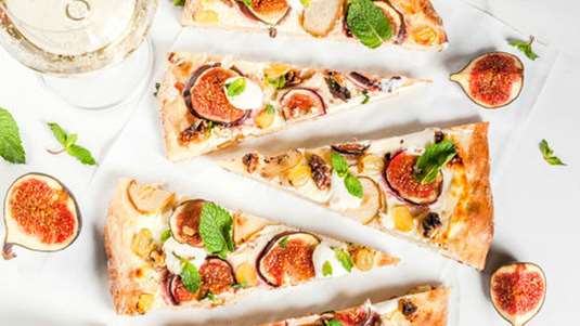 Γλυκιά πίτσα με λευκή σοκολάτα, φρέσκα σύκα, αμύγδαλα και φύλλα βασιλικού 